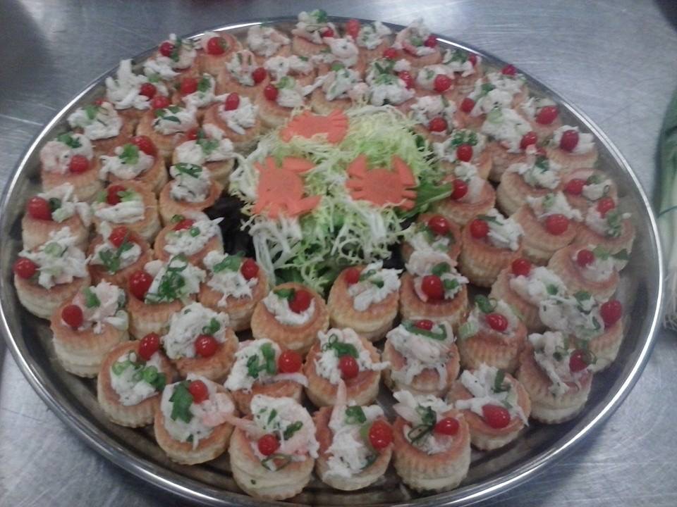 Crab salad vol-au-vents with cherry tomato and herb garnish